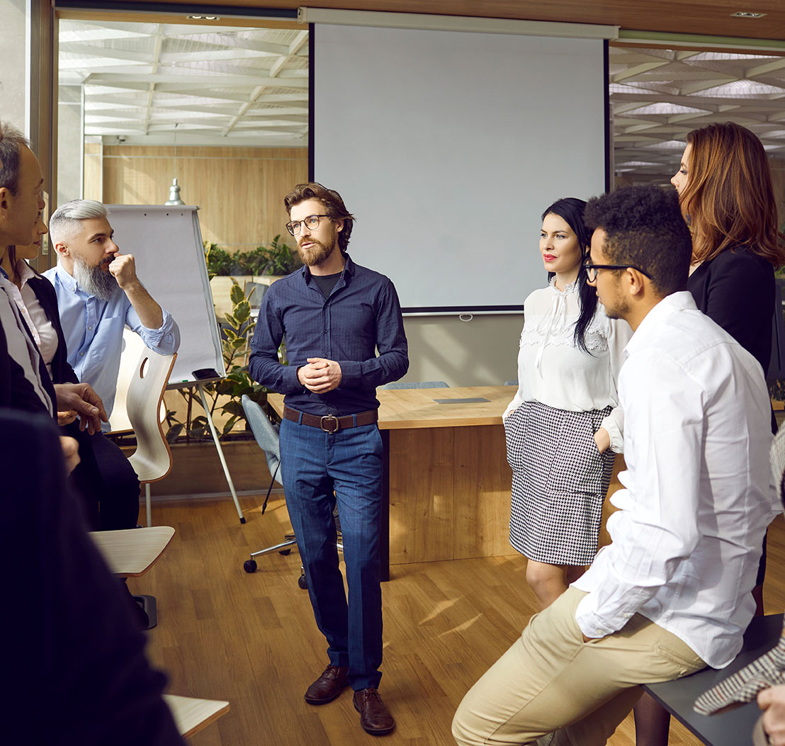 Variety of multiracial smart employees communicate at team meeting in modern office. Agile und zukunftsfähige Organisationen entwickeln